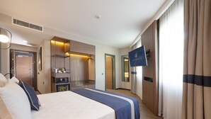 A hotel room with a bed, a TV, a wardrobe, a mirror, and a bathroom. - Granbella Hotel (Tekirdag)