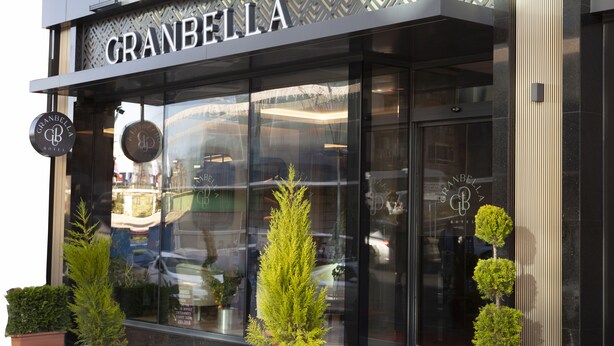 The exterior of the GranBella Hotel with its modern facade, large glass windows, and potted plants in front. - Granbella Hotel (Tekirdag)