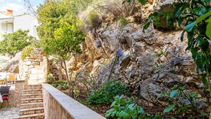 A stone staircase leading up to a white building with outdoor seating.