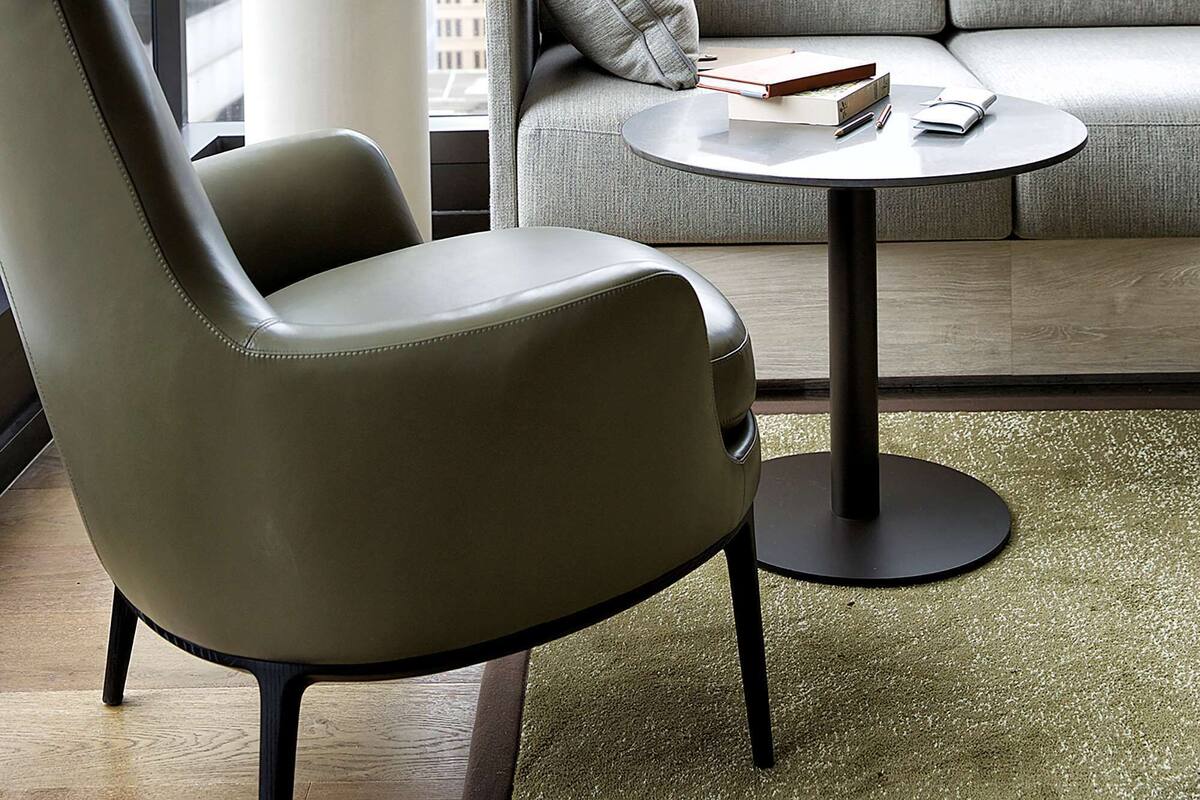 Un salon moderne avec un canapé, un fauteuil et une petite table ronde.