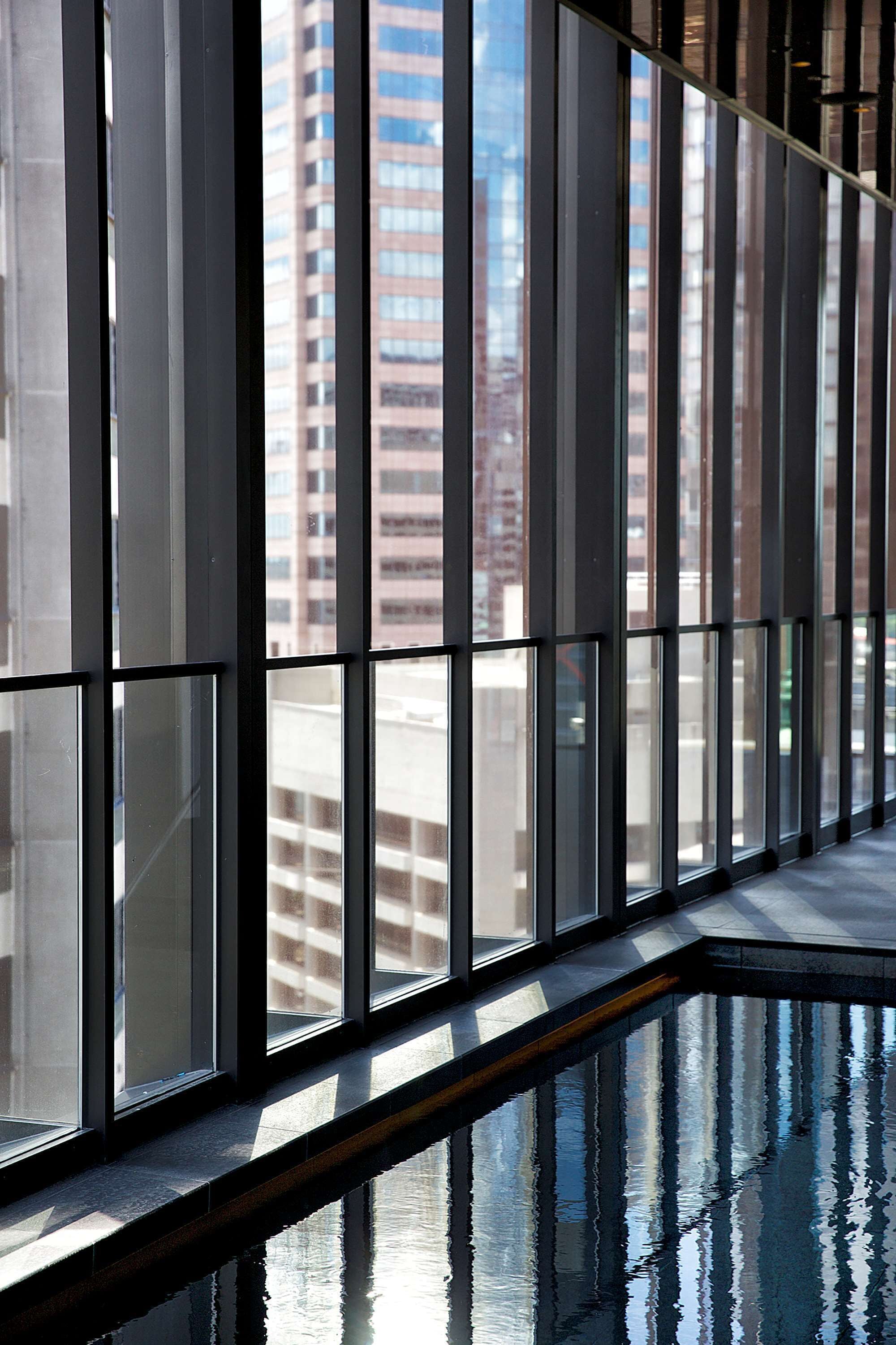 A corridor with reflective floor and large windows.