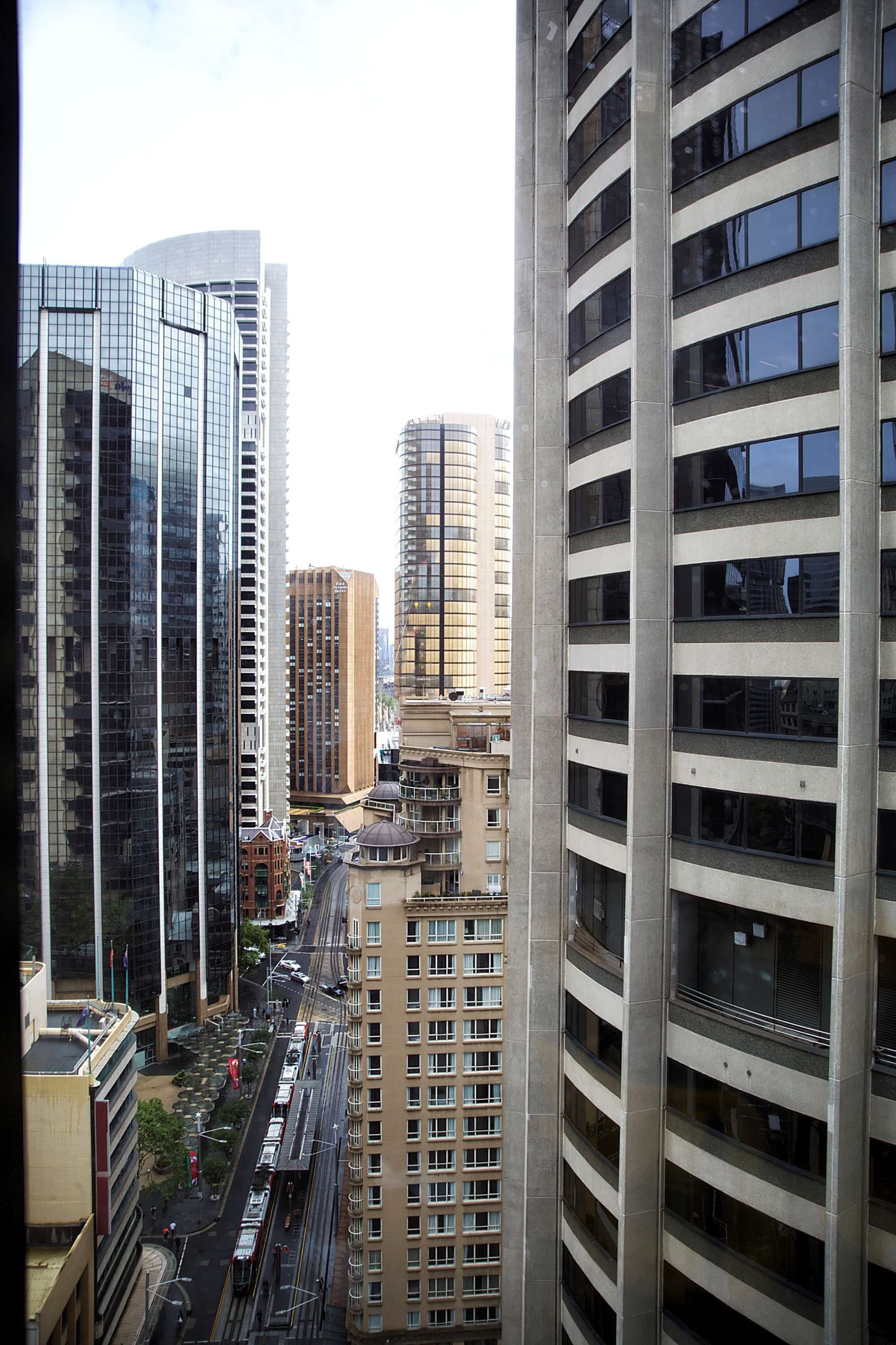 A cityscape with high-rise buildings, including a modern glass skyscraper and a classic building with a dome.