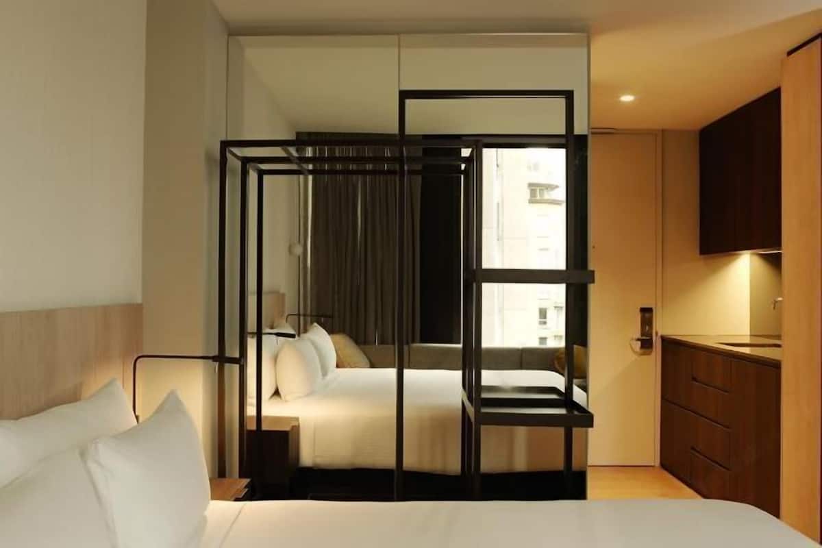 Une chambre d’hôtel avec un lit, un bureau et une vue sur la ville.