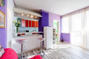 A modern kitchen with red and white cabinets, a white countertop, and a purple accent wall. - Sea View Apartments - Darijo (Dubrovnik)