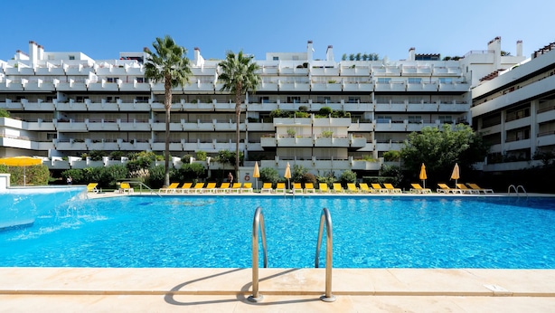 Une piscine avec un bâtiment moderne en arrière-plan.