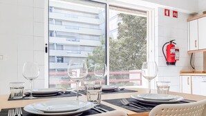 Un comedor con una mesa lista para cuatro personas, incluyendo platos, vasos y cubiertos.