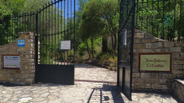 A stone pathway leading to a gated entrance with signs indicating 'Jardín Botánico El Castillo' and 'Sierra de Grazalema'. - Rural house Majaceite (El Bosque)