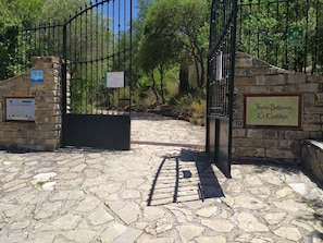 A stone pathway leading to a gated entrance with signs indicating 'Jardín Botánico El Castillo' and 'Sierra de Grazalema'. - Rural house Majaceite (El Bosque)