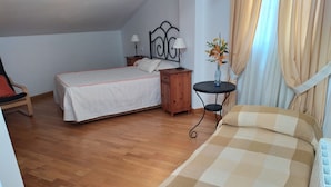 A bedroom with a bed, a wooden nightstand, a small table with a lamp, and a chair. - Rural house Majaceite (El Bosque)
