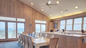 A dining area with a large table, chairs, and a view of the ocean. - Marlin Spectacular Ocean View, Inlet Point South, Beach, Pool (Pawleys Island)