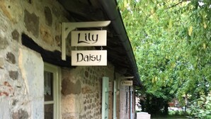 A stone building with a porch and a sign that reads "Lily Daisy." - 1 bedroom Country Cottage (Suaux)
