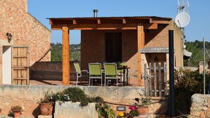 A rustic outdoor patio with wooden furniture and potted plants. - Punta de Vistalegre is a Villa with a Private Pool in a Very Quiet Rural Setting (Porto Cristo)