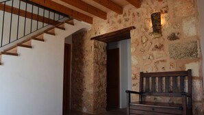 A staircase with wooden beams and a stone wall. A wooden bench is placed against the wall. - Punta de Vistalegre is a Villa with a Private Pool in a Very Quiet Rural Setting (Porto Cristo)