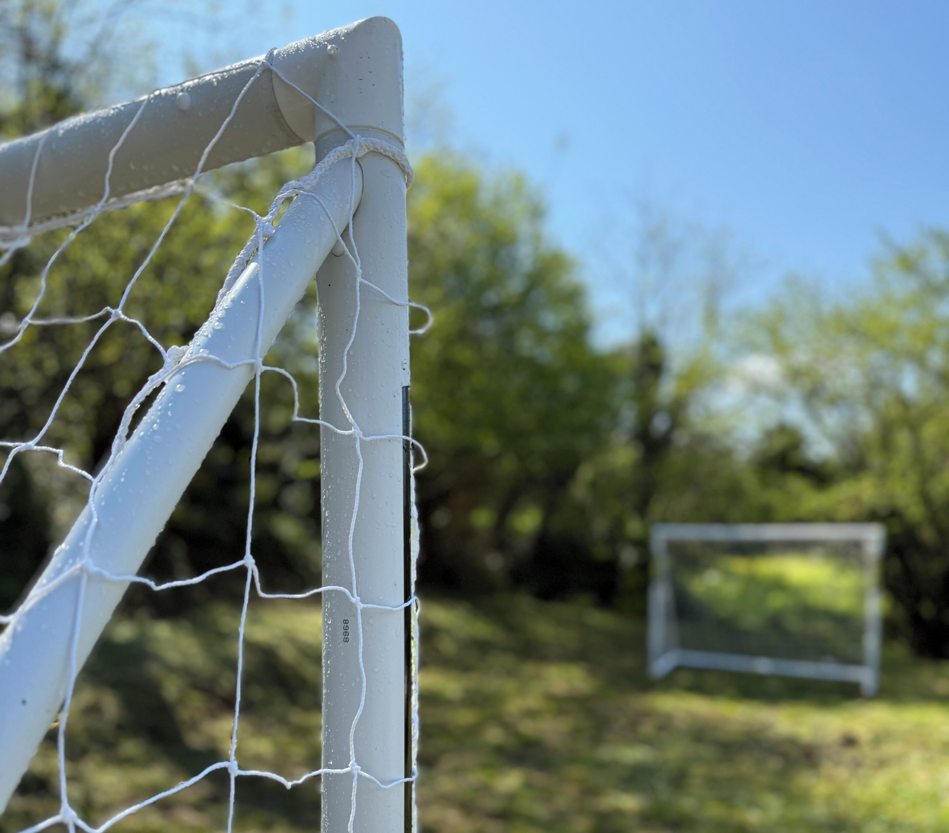 Portería de fútbol con una red, número 8968 visible en el poste, y un segundo poste al fondo.