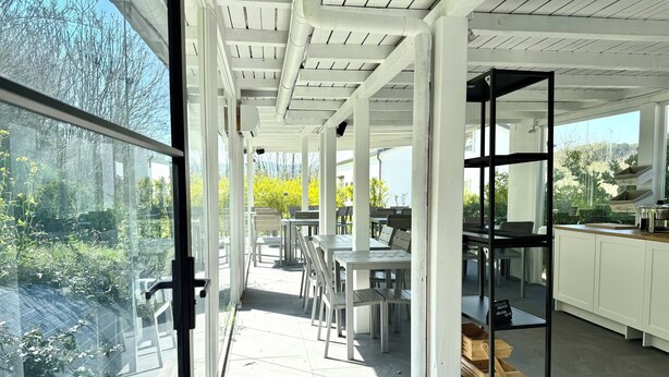 Una cocina amplia con armarios blancos, una encimera negra y vistas al exterior.