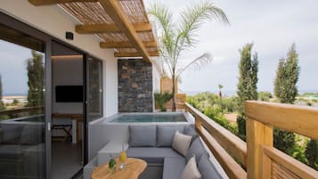 Een moderne buitenruimte met een ingebouwd whirlpool, een houten terras en uitzicht op de oceaan.