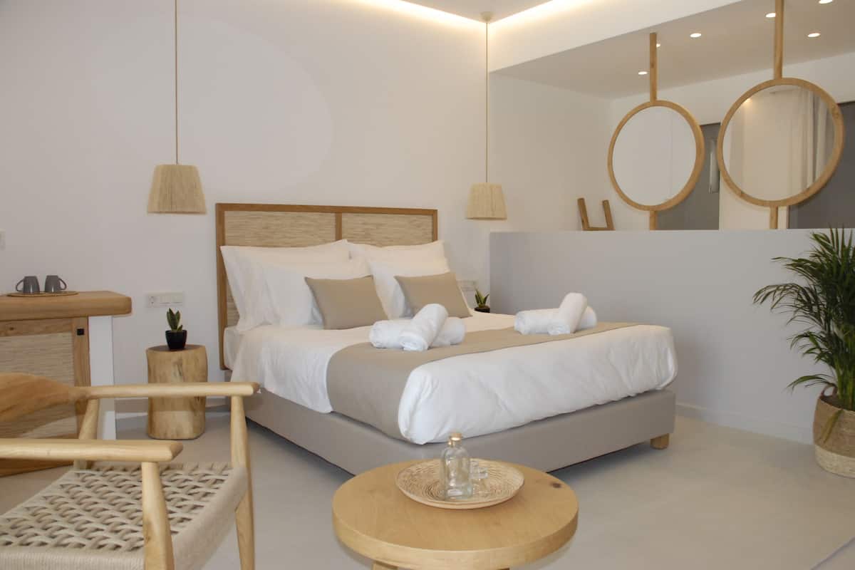 Une chambre à coucher moderne avec un lit, des tables de chevet, une chaise et une table ronde.