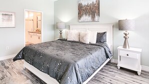 A bedroom with a bed, bedside lamps, a ceiling fan, and a painting on the wall. - 5BR Disney Villa: Pool & Spa, Game Room, Theater (Kissimmee)