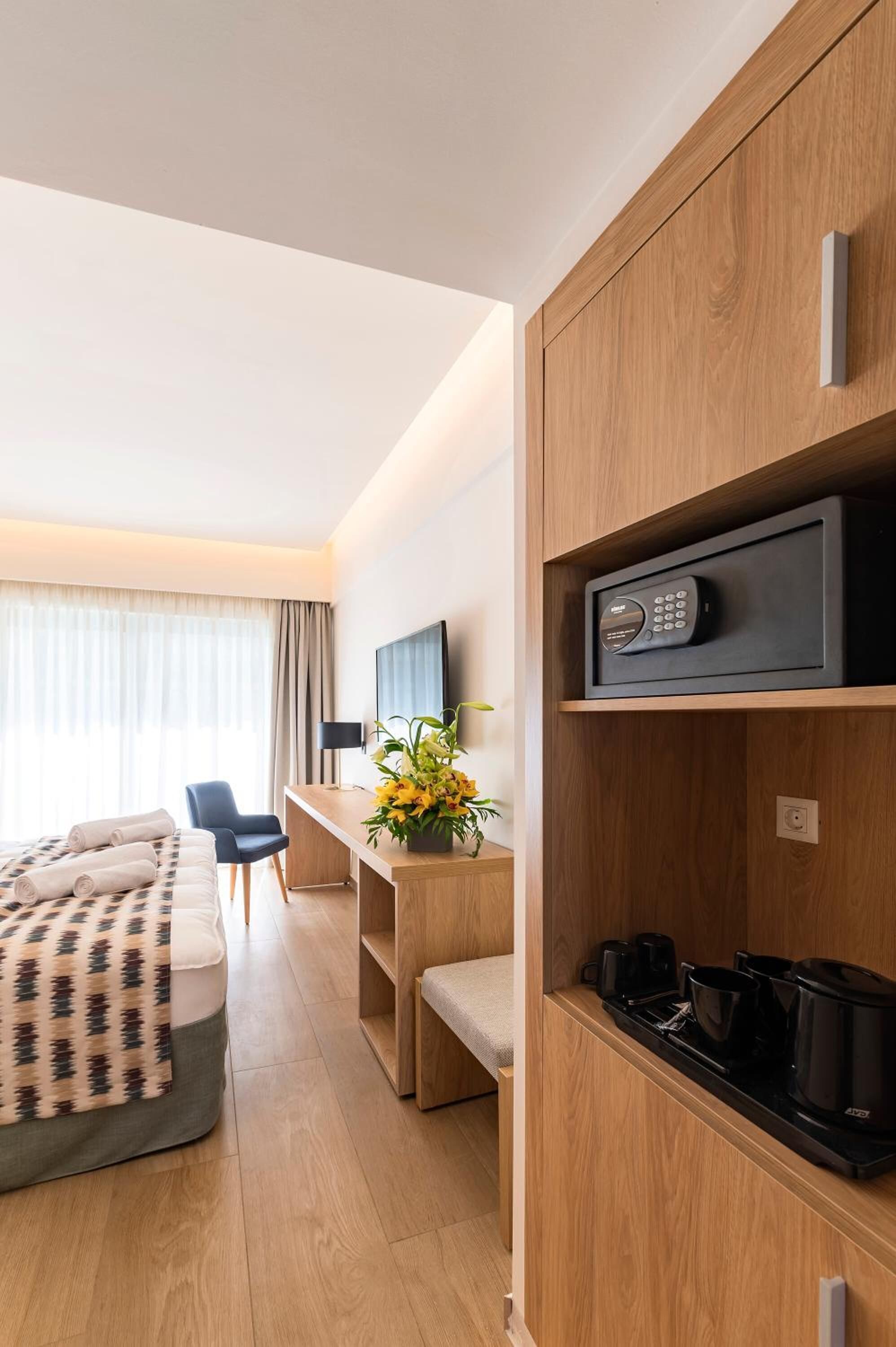 A modern hotel room with a bed, a desk, a TV, and a microwave.