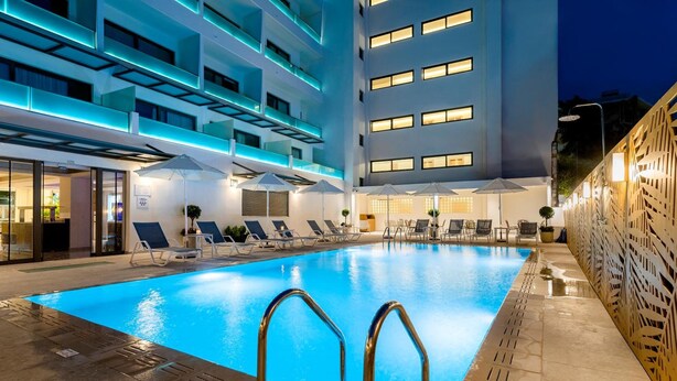 A modern hotel with a swimming pool, sun loungers, and outdoor seating. - Hotel Acandia (Rhodes)