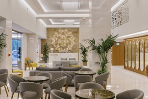 A modern reception area with a sofa, chairs, and a reception desk.