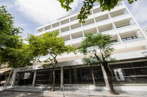 Egy modern hotel, fehér homlokzattal, számos eréllyel és üvegportálos bejárattal.