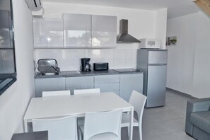 Een koelkast, een microgolfoven, kookgerei, borden en bestek