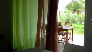 A room with a view of a patio area featuring a table and chairs. - Residence Marea, 1 bedroom apartment (Santa Lucia di Moriani)