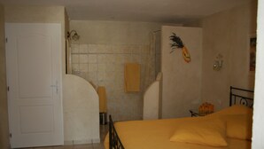 Un dormitorio con cama, ducha y puerta.