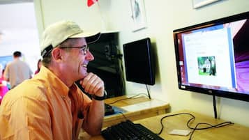 Un hombre sentado en un escritorio con un monitor de computadora mostrando una página web.