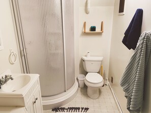 Une salle de bain équipée d’une douche, de toilettes, d’un lavabo et d’un porte-serviettes.