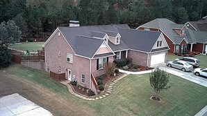 A two-story house with a garage, a lawn, and a driveway. - Spacious suite with fenced back yard, deck, gas grill, fireplaces and splash pad (Athens)