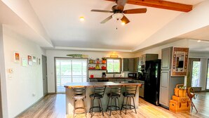 A spacious kitchen with a central island, bar stools, and a ceiling fan. - Ozark Outing - a spectacular view of the Lake of the Ozarks (Roach)