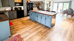 A modern kitchen with wooden flooring, grey cabinets, and a central island. - Ozark Outing - a spectacular view of the Lake of the Ozarks (Roach)