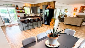 A modern dining area with a black table, grey chairs, and a potted plant centerpiece. - Ozark Outing - a spectacular view of the Lake of the Ozarks (Roach)