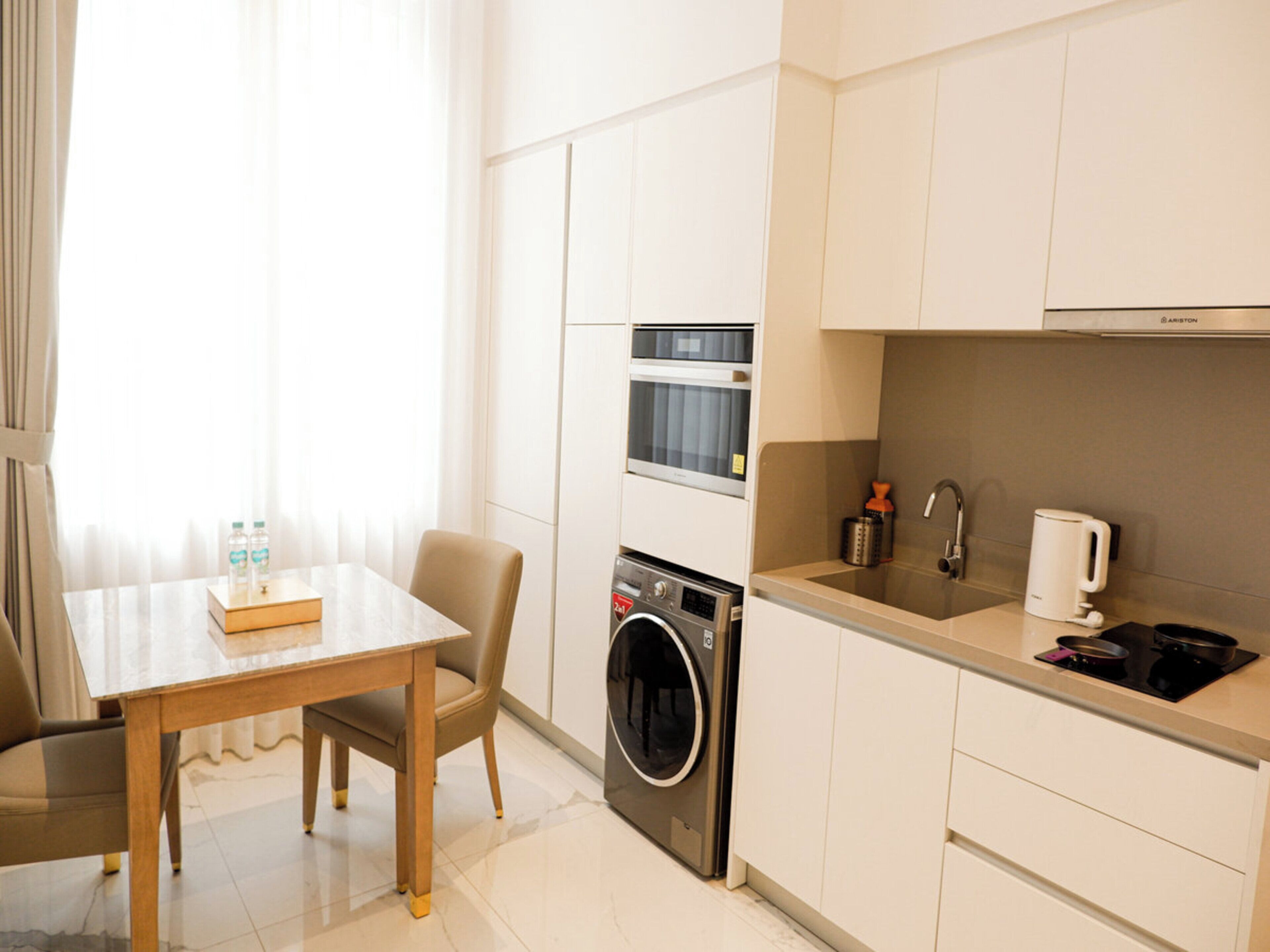 A compact kitchen with a washing machine, a microwave, and a sink.