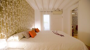 A bedroom with a large bed, a patterned wall, and a view of the outside. - Spacious Apartment in Palma Old Town, Wifi, Air Conditioning, Fully Equipped (Palma)