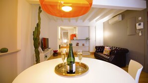 A dining area with a round table, a bottle of champagne, and two glasses. - Spacious Apartment in Palma Old Town, Wifi, Air Conditioning, Fully Equipped (Palma)