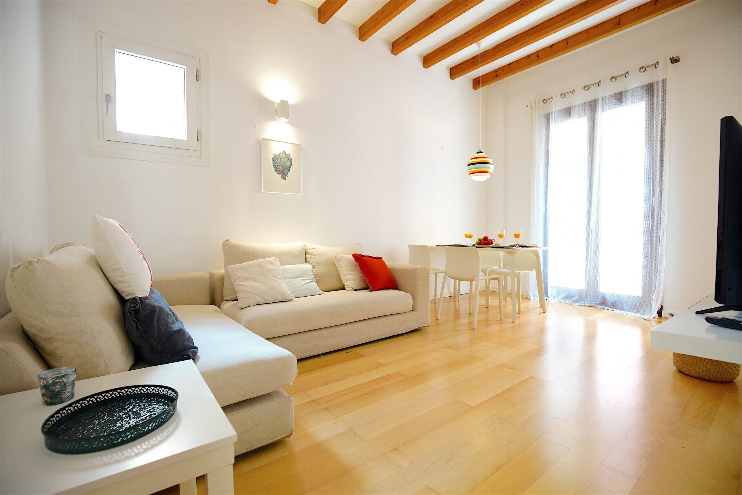 Een moderne woonkamer met een bank, een eettafel en een televisie.
