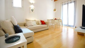 Un salon moderne avec un canapé, une table à manger et un téléviseur.