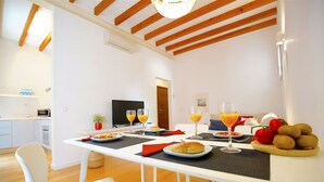 Un espace de salle à manger moderne avec une table blanche, des chaises et un plafond en bois.