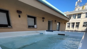 A rooftop swimming pool with a clear blue sky in the background.