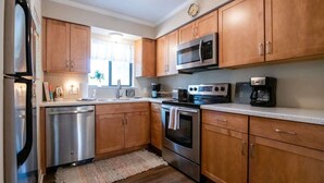 Una cocina moderna con armarios de madera, electrodomésticos de acero inoxidable y lavavajillas.
