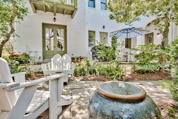 Relax in a serene outdoor space surrounded by lush greenery and comfortable seating.