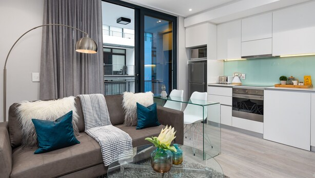 Un salon moderne avec un canapé, une table basse et une table à manger en verre.