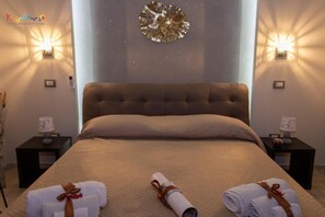 Een hotelkamer met een groot bed, twee nachtkastjes en wandlampen.
