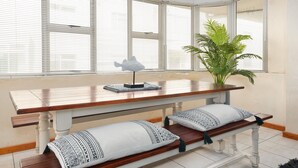 A dining area with a wooden table, benches, and a potted plant.