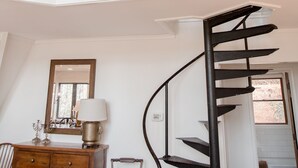 Un interior espacioso con una escalera curva que sube a un segundo piso.