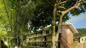 A multi-story building with a flat roof, large windows, and a staircase leading to the upper levels. - Bugio Flats (Angra dos Reis)