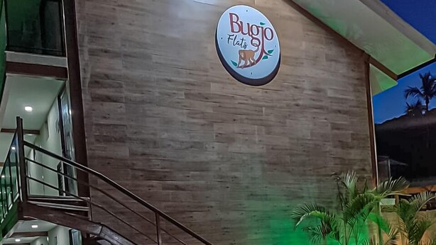 A building with a sign reading "Bugio Flats" and a staircase leading to an entrance. - Bugio Flats (Angra dos Reis)